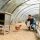 portrait of handsome young farmer veterinarian taking care of poultry in small chicken farm